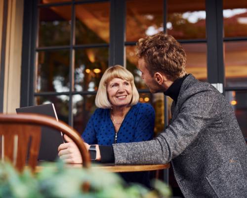 young-guy-formal-clothes-have-business-talk-with-old-woman-cafe